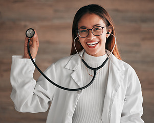 Image showing Healthcare, happy and portrait of a doctor with a stethoscope isolated on a clinic wall. Smile, consulting and a woman in medicine for a consultation, cardiology and medical analysis at a hospital