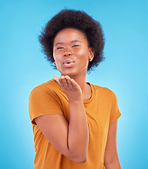 Image showing Portrait, black woman and blowing kiss on blue background of love, care and flirting in studio, color backdrop and face. Happy female model, hand kisses and emotion of happiness, fun or kissing emoji