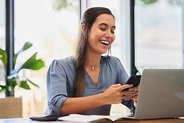 Image showing Phone, happy and business woman laughing while texting in office, typing and reading meme while working on a laptop. Funny, online and social media joke by lady employee enjoying humor, break or text