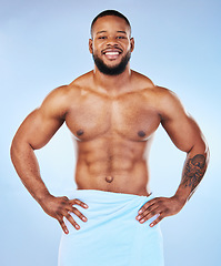 Image showing Man body muscle, towel and portrait of a male smile with happiness from bodybuilder exercise. Cleaning, skincare and wellness after workout and fitness with isolated, studio and blue background