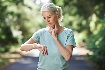 Image showing Senior woman, watch and pulse outdoor for exercise on run, workout and training on road for fitness. Elderly female person check cardio progress time for health and wellness while running in nature