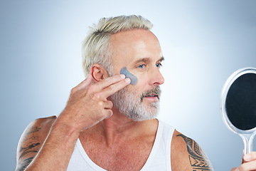 Image showing Mirror, skincare and facial with mature man in studio for cleansing, detox and spa treatment. Cosmetics, clay mask and face with senior model on gray background for anti aging, product and natural