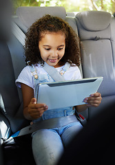 Image showing Happy, watching and a child in a car with a tablet for a movie, cartoons or video. Smile, travel and a girl sitting in a vehicle with tech, streaming online and enjoying a film for entertainment