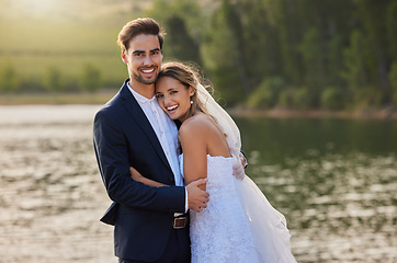 Image showing Happy wedding couple, portrait and hug by lake for romantic honeymoon getaway in nature. Man and woman hugging in happiness for marriage relationship or loving embrace in commitment in the outdoors