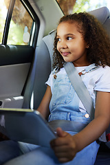 Image showing Child in car, smile and tablet on road trip with seatbelt for safety and device to watch educational video or online game. Technology, internet and travel, happy girl on backseat for drive or carpool