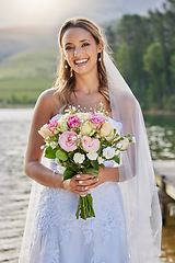 Image showing Portrait, bride and smile with flower bouquet at lake, nature and celebration of commitment, love and marriage. Happy woman, wedding and flowers outdoor for bridal fashion, style and excited ceremony