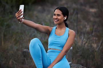 Image showing Woman outdoor, runner and fitness selfie, smile with earphones and running in nature with live streaming for social media. Exercise, cardio and happy in picture, break after run and listen to music