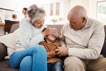 Image showing Happy, playful and child with grandparents on sofa of family living room for bonding, affectionate and fun. Playing boy, hide and seek with senior people at home for happiness, generations and games