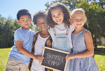 Image showing Summer camp, portrait or kids hugging in park together for fun, bonding or playing in outdoors. Boys, girls or happy young best friends smiling or embracing on school holidays outside with board sign