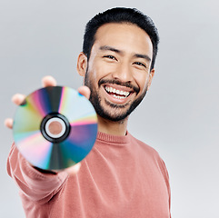 Image showing Happy, showing and portrait of an Asian man with a cd isolated on a white background in a studio. Smile, excited and a Japanese person with a copy of multimedia, music or a movie on a backdrop