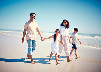 Image showing Beach, family holding hands and parents with kids playing and walking on ocean sand together. Fun, vacation and happy man and woman with children bonding, quality time and summer with mom and dad.