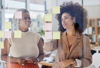 Image showing Team, brainstorming and business people with glass board, writing ideas on sticky note with collaboration and strategy. Planning, meeting and women working together, female employees and partnership