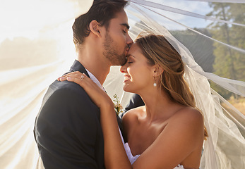 Image showing Couple, wedding and forehead kiss with vail for love, compassion or affection together in nature. Marred man kissing woman on head and hugging in marriage, relationship or loving embrace outdoors