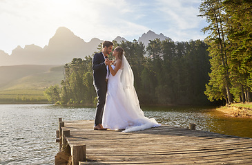 Image showing Love, dance and a married couple on a pier over a lake in nature with a forest in the background after a ceremony. Wedding, romance or water with a bride and groom in celebration of marriage outdoor