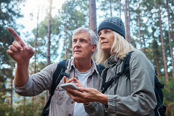 Image showing Hiking, senior couple and phone outdoor in nature for direction for exercise, fitness and trekking. Old man and woman with smartphone pointing on forest hike for workout, cardio and gps or compass