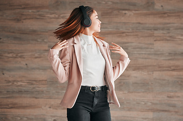 Image showing Dancing, happy and woman listening to music with happiness or streaming audio online using headphones. Radio, wellness and excited female person dance isolated in a wooden wall background