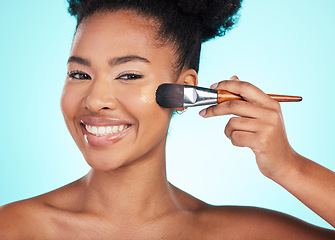 Image showing Black woman, foundation and brush in studio for beauty with skin test, smile and cosmetics by blue background. Happy african model, girl and makeup for aesthetic, glow and skincare with concealer