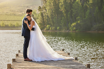 Image showing Wedding couple, hug and love by lake in nature for relax or romantic honeymoon getaway. Calm woman hugging man in happy marriage relaxing by water together enjoying the loving embrace outdoors