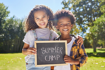 Image showing Summer camp sign, portrait or happy kids hug in park together for fun, bonding or playing in outdoors. Board, diversity or young best friends smiling or embracing on school holidays outside in nature