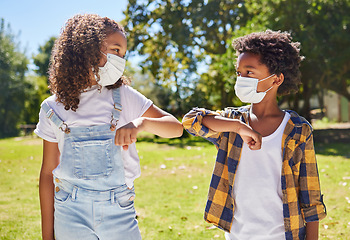 Image showing Children, park and mask for covid with elbow touch with support, care or outdoor in summer sunshine. Kids, friends and greeting girl, safety and solidarity at school, playground and backyard lawn