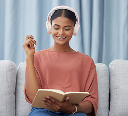 Image showing Writing woman, couch and headphones in a living room with a smile from planner notes. Home, journal and creative writer with ideas and on a lounge sofa in house with happiness from notebook planning