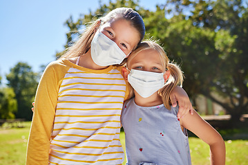 Image showing Portrait, mask and friends hug, outdoor while bonding, loving together and relax. Kids, young girl and student children embrace and cover faces outside at park or garden in covid pandemic at school