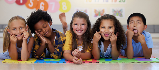 Image showing Kids, floor and group portrait with funny face in school classroom, solidarity or diversity in childhood. Girl, boy and children in class, academy and happy multicultural friends, together or playful