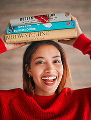 Image showing Reading, portrait and student with books on her head while studying in college for a test or exam. Happy, smile and excited young woman with stories, novels or fiction standing by wall in the library