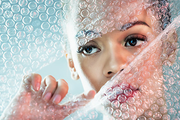 Image showing Bubble wrap, cosmetics and face of woman with makeup, red lipstick and skincare products in studio. Creative art, beauty mockup and girl with facial glow, aesthetic and luxury style with plastic tear