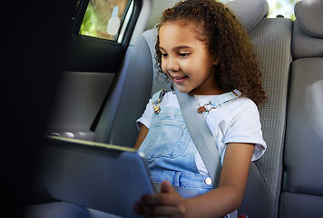 Image showing Child in car, tablet and video on road trip with seatbelt for safety and device to play educational online game. Technology, internet browsing and travel, happy girl on backseat for drive or carpool.