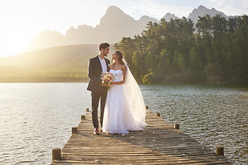 Image showing Love, married or romance with a bride and groom on a pier over a forest lake in nature after their ceremony. Wedding, love and water with a young couple in celebration of their marriage outdoor