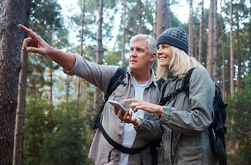 Image showing Senior couple, hiking and phone outdoor in nature for direction for exercise, fitness and trekking. Old man and woman with smartphone and hand on forest hike for workout, cardio and gps or compass