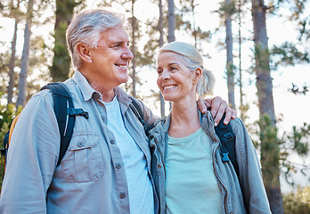 Image showing Senior couple, hiking and happy outdoor in nature for exercise, fitness and trekking for health and wellness. Old man and woman smile and hug on hike in forest for workout, cardio and retirement