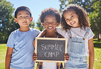 Image showing Summer camp, portrait or children with board in park together for fun, bonding or playing in outdoors. Sign, diversity or happy young best friends smiling or embracing on school holidays outside