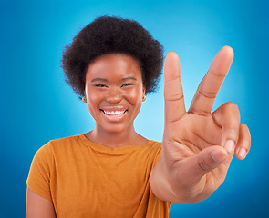 Image showing Peace sign closeup, black woman hand and portrait of a model with a smile and happiness. Isolated, blue background and v hands gesture of a young female with a afro and beauty feeling excited