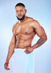 Image showing Black man, portrait and body with a towel in studio for health, wellness and fitness. Face of serious male aesthetic model for clean body, strong muscle and skincare on a gradient blue background