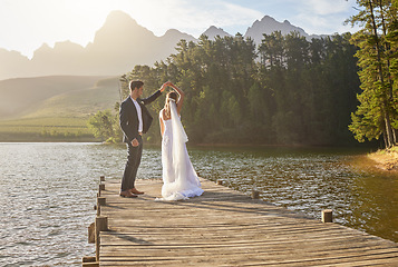 Image showing Married, dance and a couple on a pier over a lake in nature with a forest in the background after a ceremony. Wedding, love or water with a bride and groom in celebration of their marriage outdoor