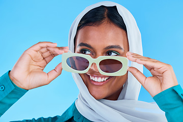 Image showing Fashion sunglasses, face or happy Muslim woman with hijab, designer brand glasses or casual outfit style. Gen z summer aesthetic, Islamic model smile and Arabic Islam female on blue background studio