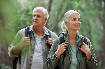 Image showing Elderly couple, hiking and active seniors in a forest, happy and relax while walking in nature. Senior, backpacker and woman with man outdoors for travel, freedom and healthy lifestyle in retirement