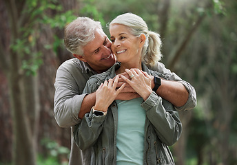 Image showing Hug, hiking and senior couple in nature with smile on adventure in forest, woods and mountain for exercise. Fitness, retirement and happy elderly man and woman on trekking hike for travel wellness