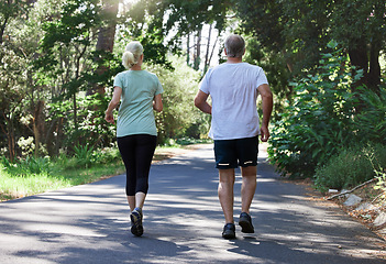 Image showing Senior couple, running and back outdoor for exercise, workout and training on road for fitness. Elderly man and woman together for cardio health and wellness on run in nature forest for retirement