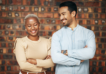 Image showing Happy, professional team and partnership, collaboration with smile and arms crossed with friends against brick wall. Work together, employees and diversity, black woman and man, teamwork and trust