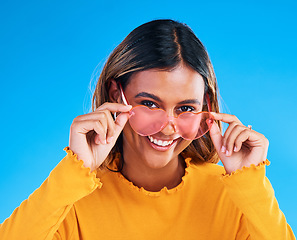 Image showing Fashion portrait, heart glasses and happy woman with young style, designer brand or casual summer outfit. Trendy gen z aesthetic, girl smile and female model face on blue background studio