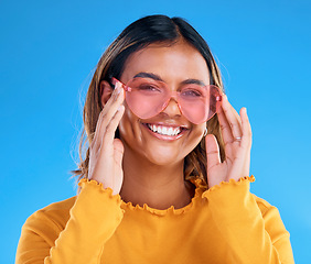 Image showing Fashion, smiling or woman portrait with heart glasses, luxury designer brand style or casual summer outfit. Gen z aesthetic, trendy sunglasses accessory or female face model on blue background studio