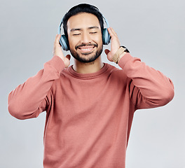 Image showing Listen, happy and Asian man with headphones, streaming music and sounds against a white studio background. Japan, male and guy with headset, listening to radio and podcast for motivation and wellness