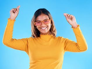 Image showing Fashion portrait, dance and woman smiling with sunglasses, designer brand style or happy casual outfit. Gen z aesthetic, trendy glasses accessory or excited female celebrate on blue background studio