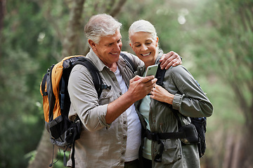 Image showing Phone, video call and elderly couple hiking in a forest, happy and smile while bonding on adventure. Active seniors, online and maps for man and woman backpacking in nature while checking location