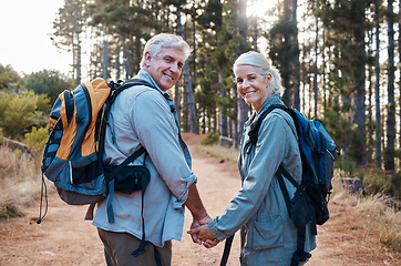 Image showing Love, hiking and portrait of old couple holding hands on nature walk in mountain forest in Canada. Travel, senior man and woman on hike with smile on face and health on retirement holiday adventure.