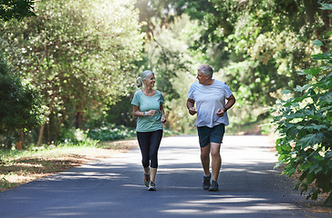 Image showing Senior couple, exercise and happy outdoor for a run, workout and training on road for fitness. Elderly man and woman talking about cardio for health and wellness while jogging or running in nature