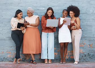 Image showing Happy, talking and women on a brick wall with tech for communication, social network and advice. Team, diversity and group of female employees speaking while using technology in the city for work